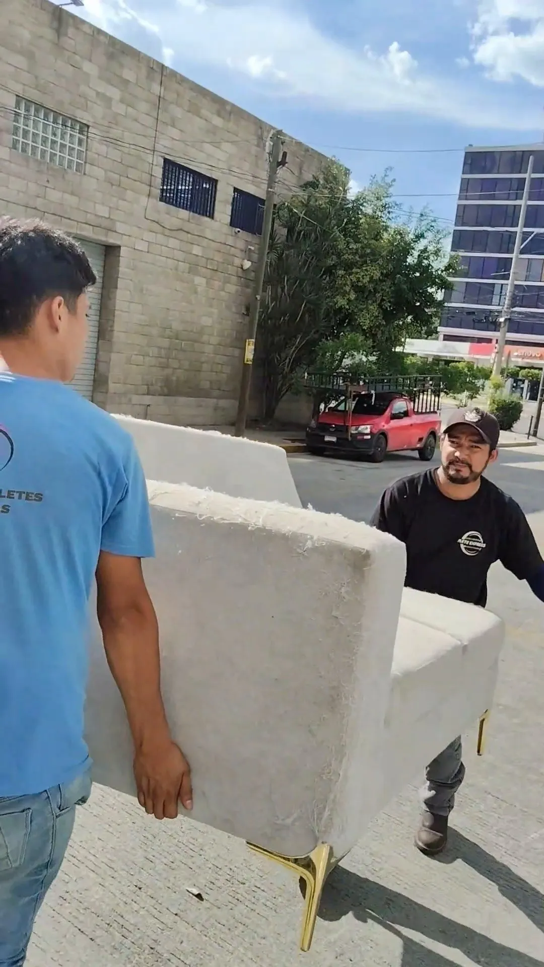 Dos integrantes del equipo cargando un sillón