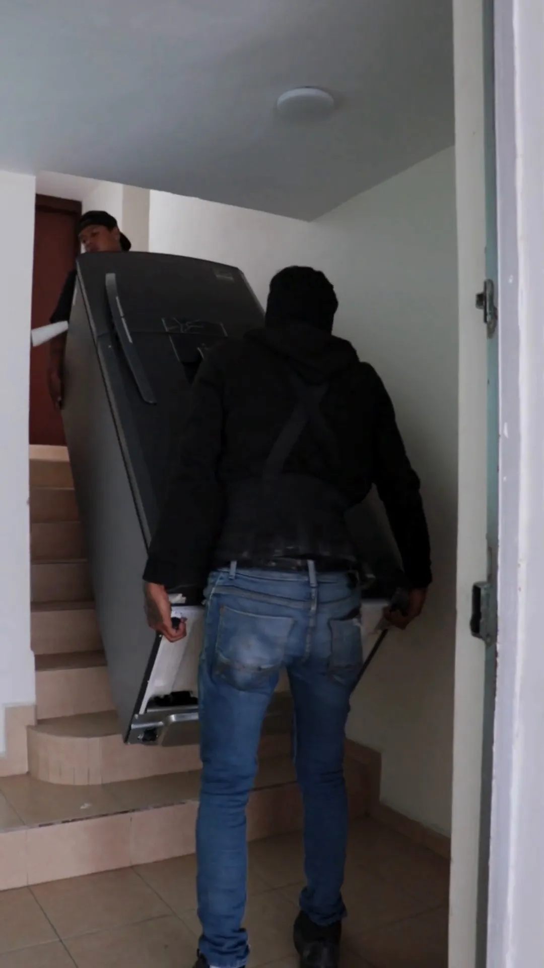 Dos integrantes subiendo un mueble por la escalera interior